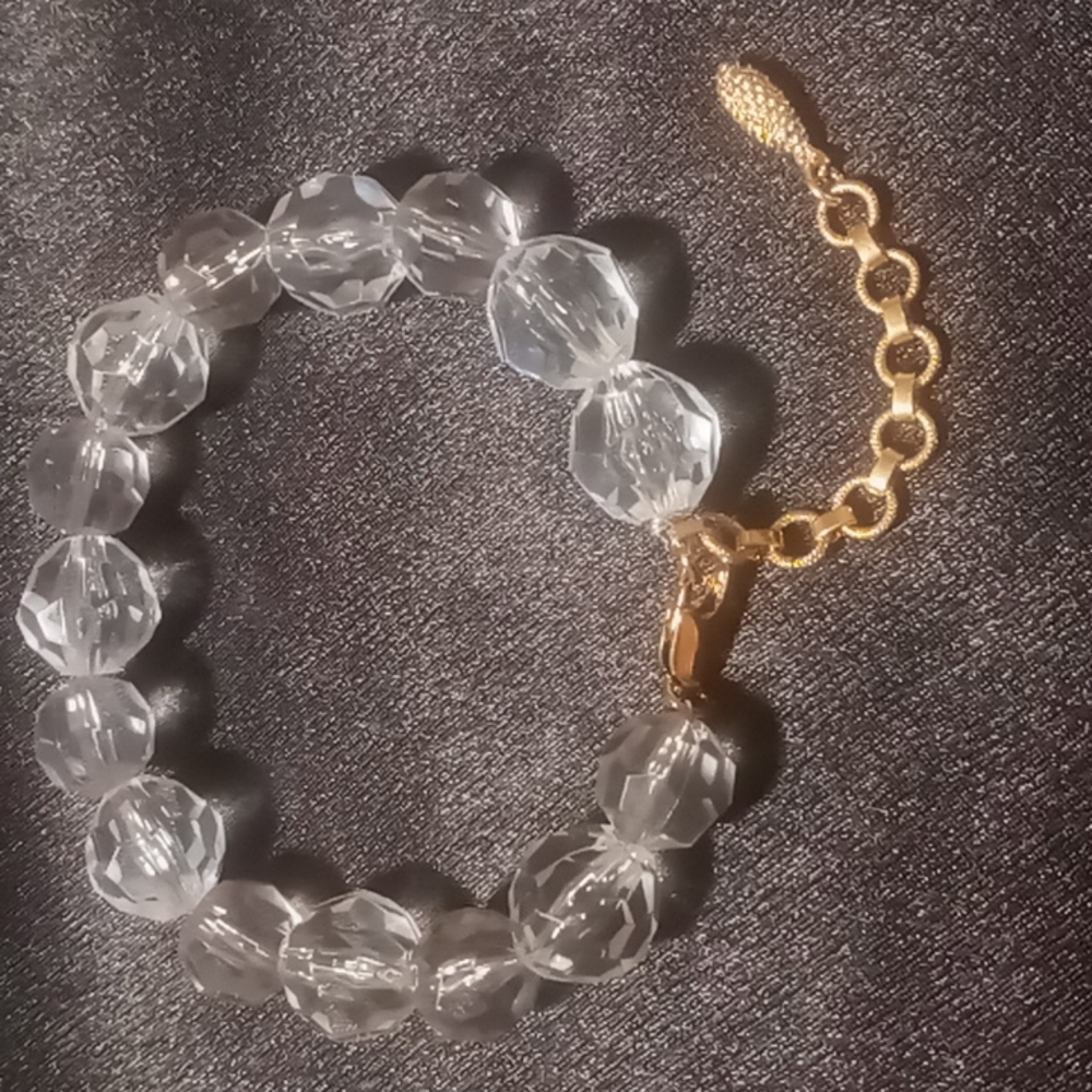 Clear beaded bracelet on wire with gold tone lobster clasp extendable clasp.